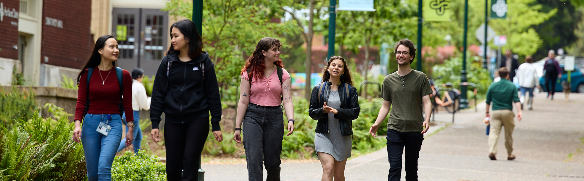 Group of students walking together on a campus walkway.