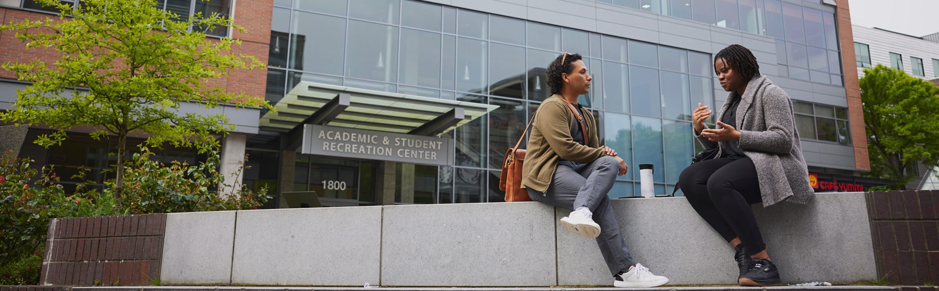 Two students talking outdoors on campus.