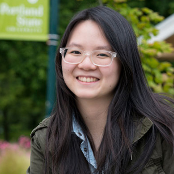 A student smiling outside